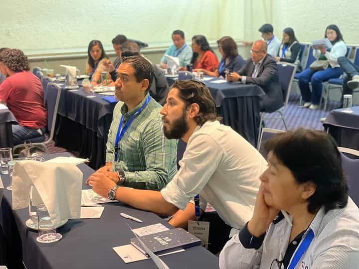 Asistentes del Congreso Latam 2025 sentados en mesas durante una conferencia en la Ciudad de México