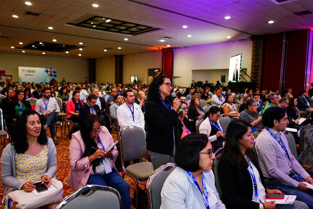 Asistente de pie interviniendo con micrófono durante una sesión de debate del Congreso Latam 2023