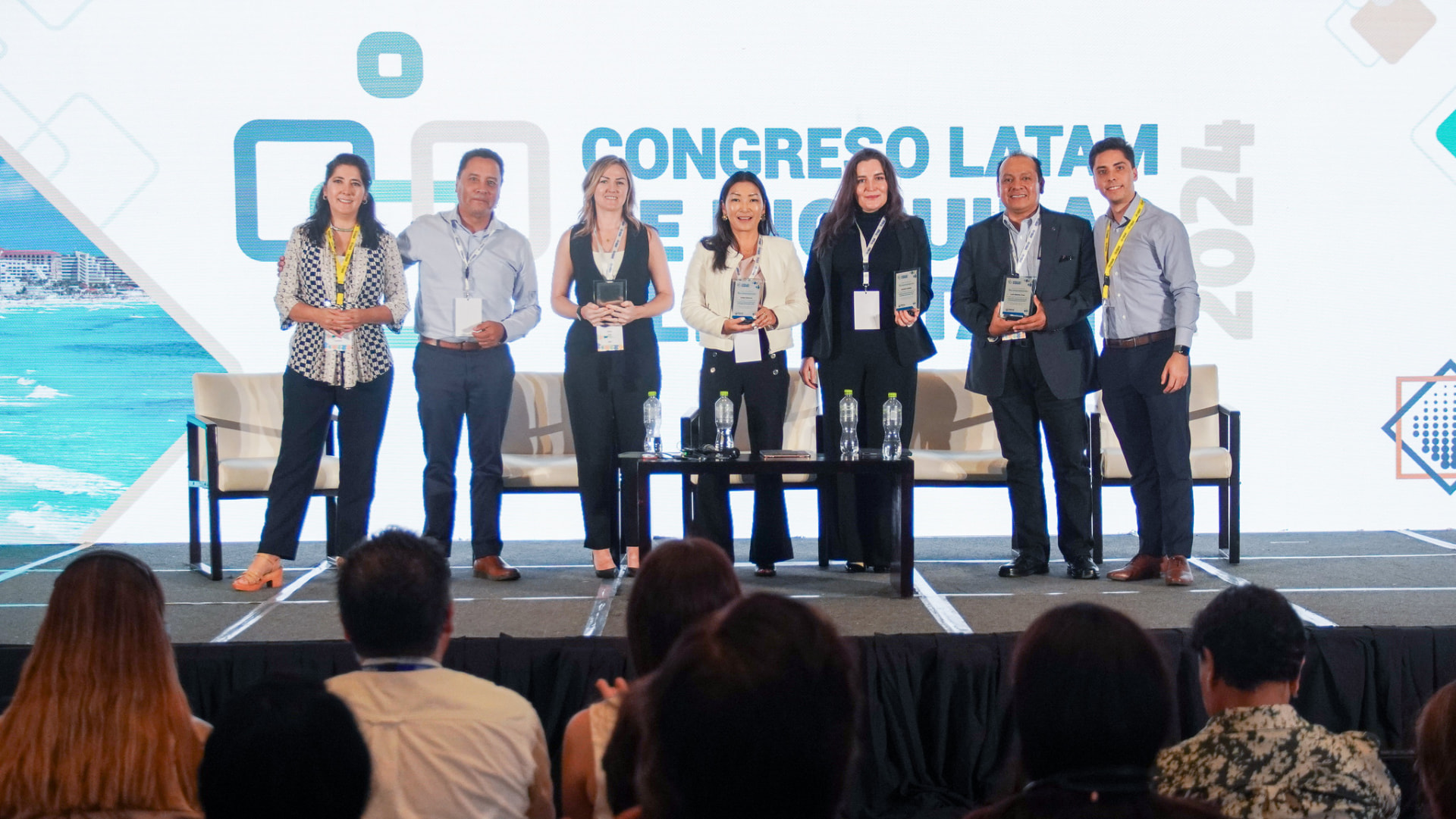 Grupo de ponentes y homenajeados con sus reconocimientos en el escenario del Congreso Latam 2024