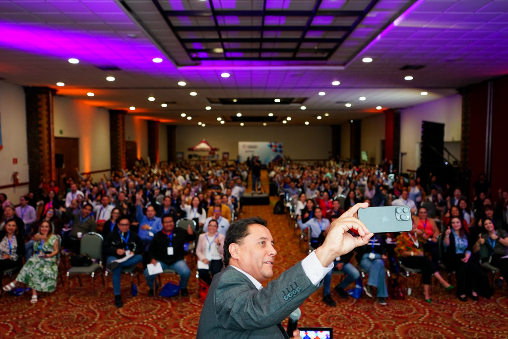 Asistente tomando una selfie con la multitud durante el ambiente animado del Congreso Latam 2023 en Querétaro