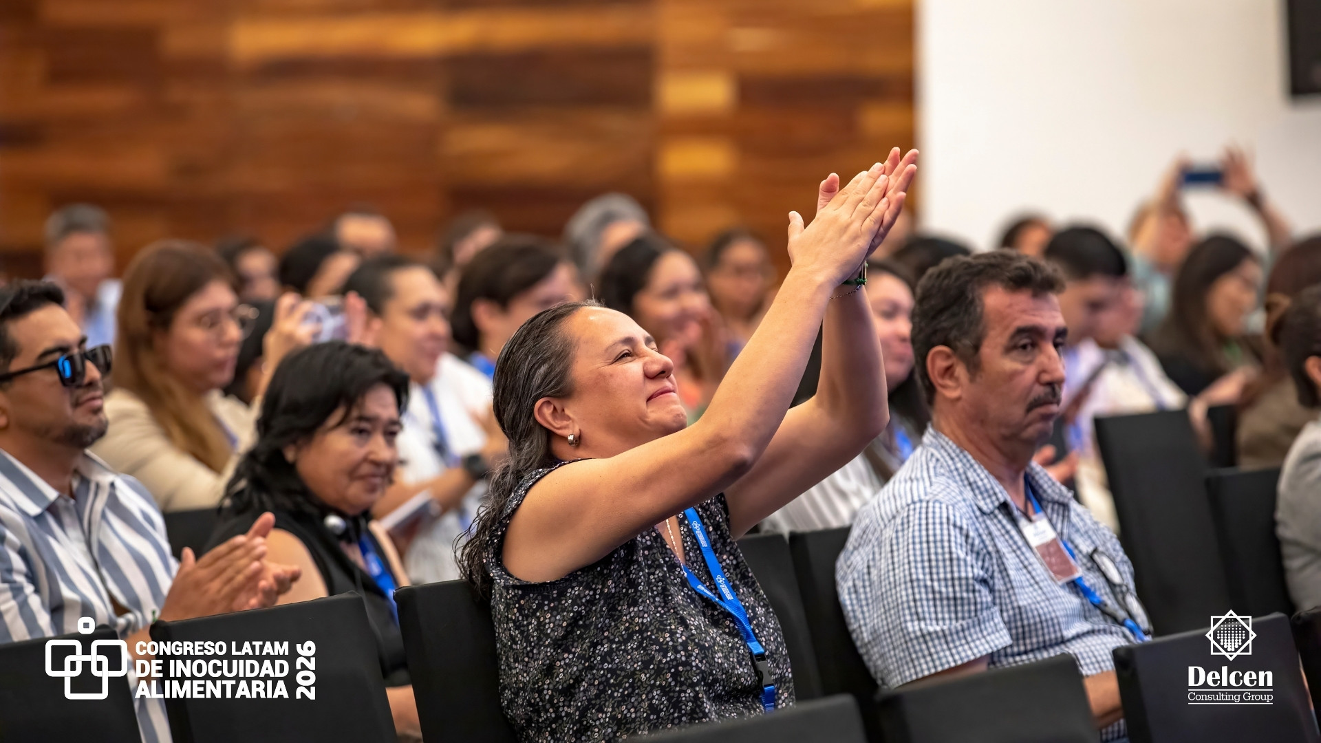 Asistente del Congreso Latam 2026 aplaude sonriente durante una sesión en Puerto Vallarta